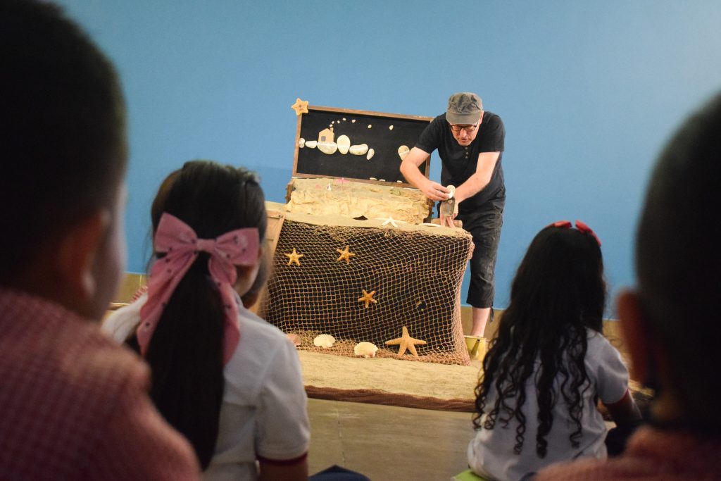 Fotografía de obra de teatro en el que el intérprete manipula elementos con sus manos